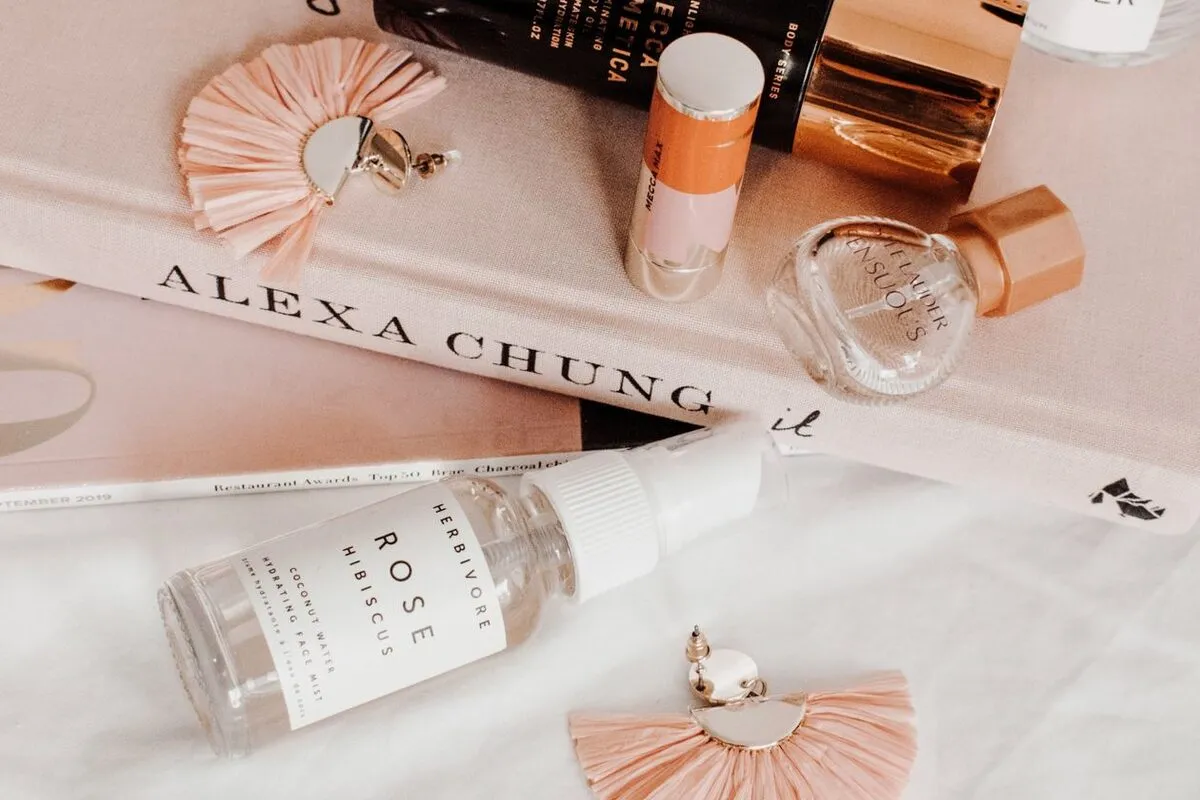 An overhead flat lay of cosmetic products arranged with supporting props
